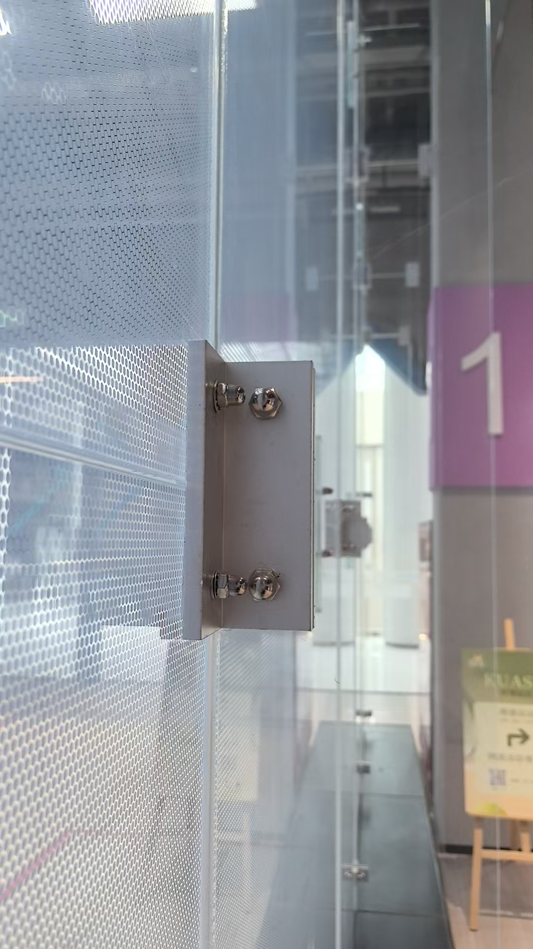 Actual photograph of a squash court glass connection and fixing hardware
